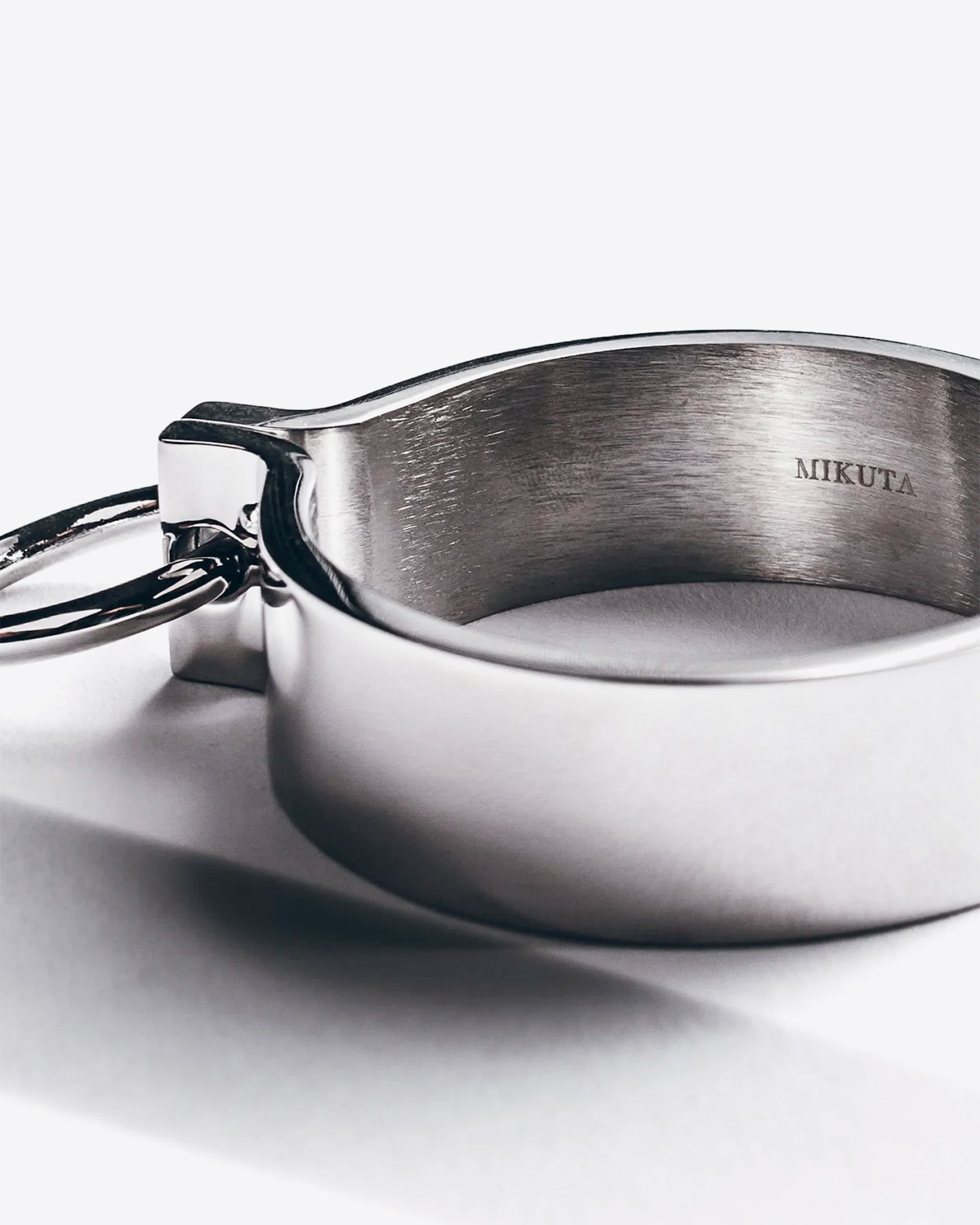 Bracelet manchette en argent avec une fermeture aimant et un anneau Mikuta. Détail de la signature gravée Mikuta à l'intérieur du bracelet.