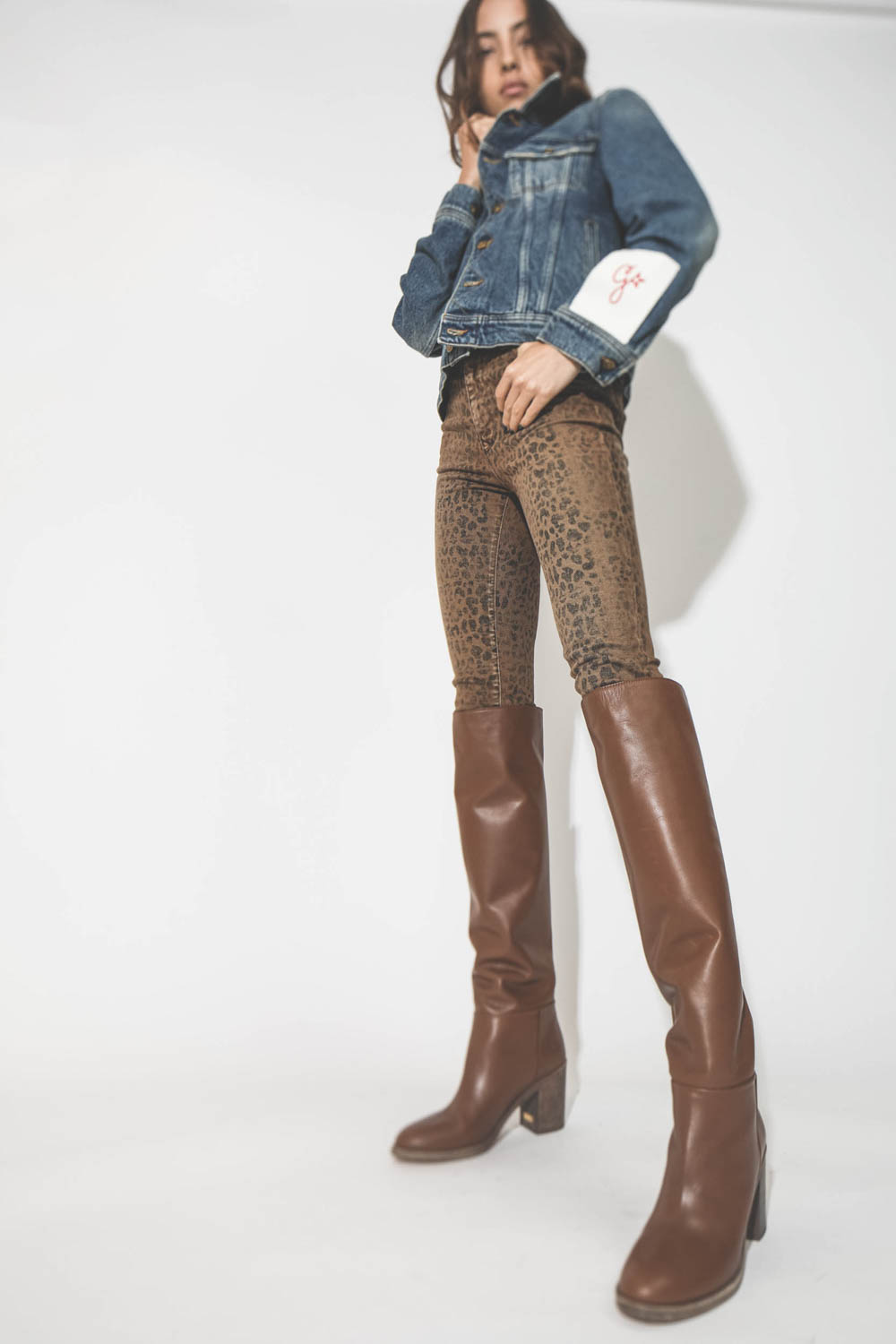 Blouson en jean bleu ciel Golden Goose. Porté avec des bottes en cuir camel.