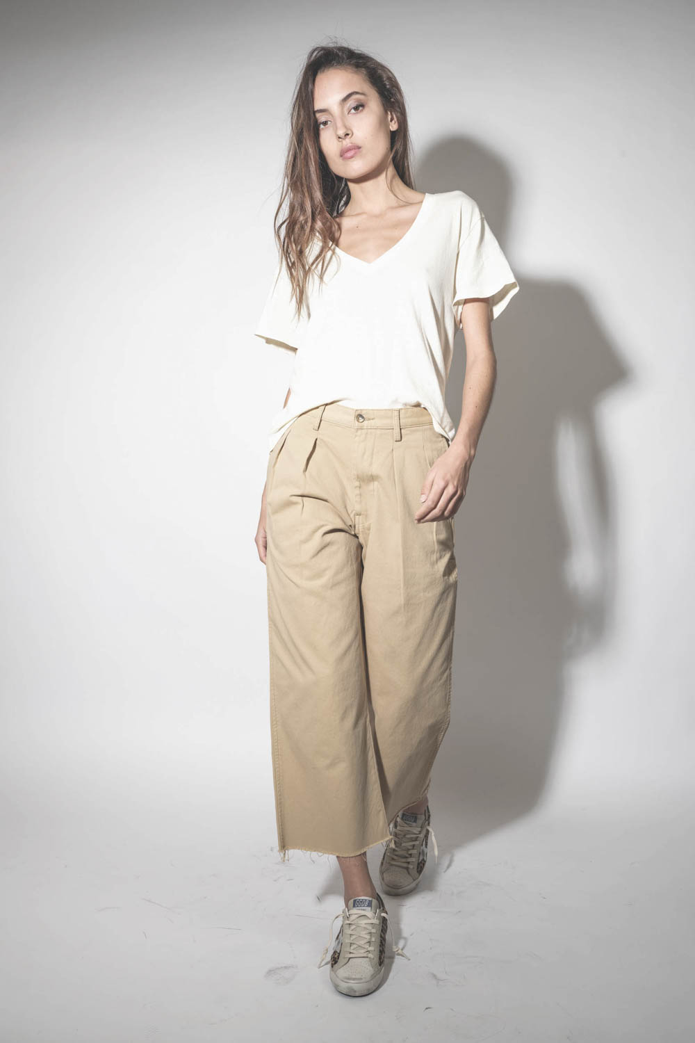 Pantalon large à pinces en toile de coton beige Chino Denimist. Porté avec des sneakers léopard.