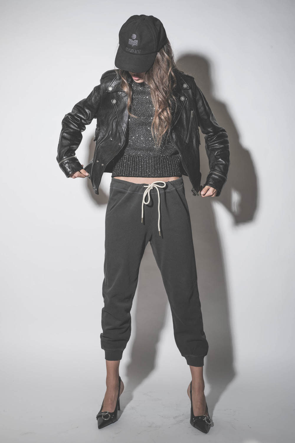 Blouson Perfecto en cuir brillant noir Nevada Golden Goose. Porté avec un pull en maille lurex noir.