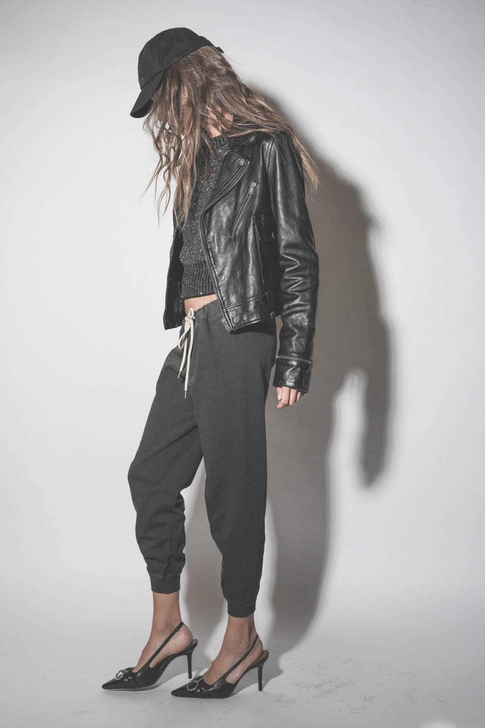 Blouson Perfecto en cuir brillant noir Nevada Golden Goose. Porté avec un bas de jogging noir.