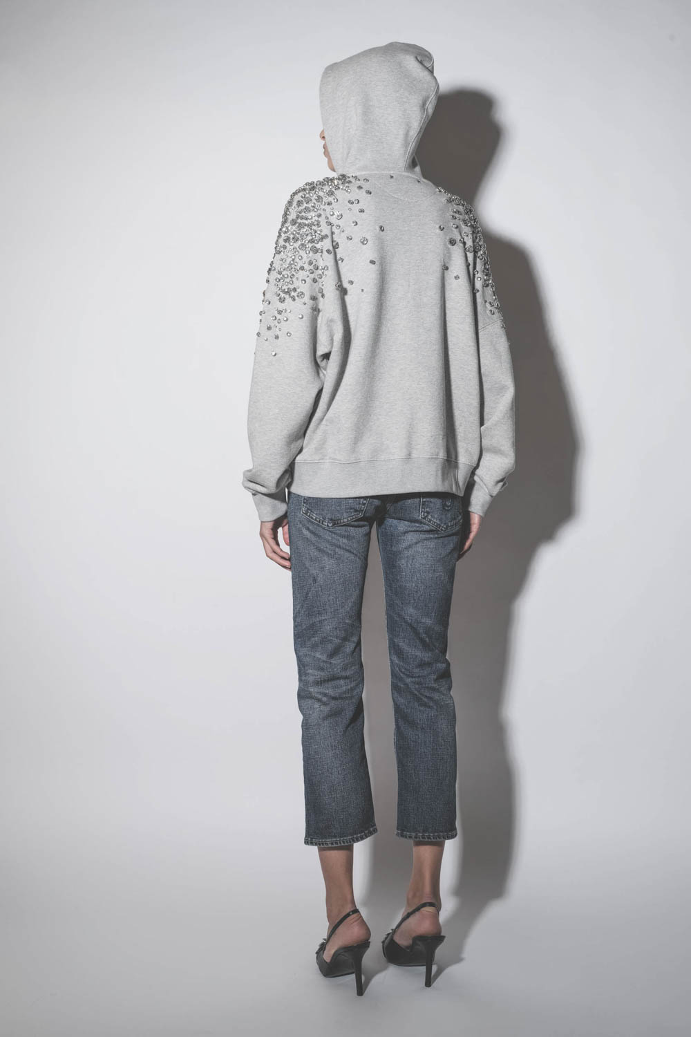 Sweatshirt à capuche gris chiné brodé de pierres en cristal sur les épaules et les bras Golden Goose. Porté de dos capuche relevée.