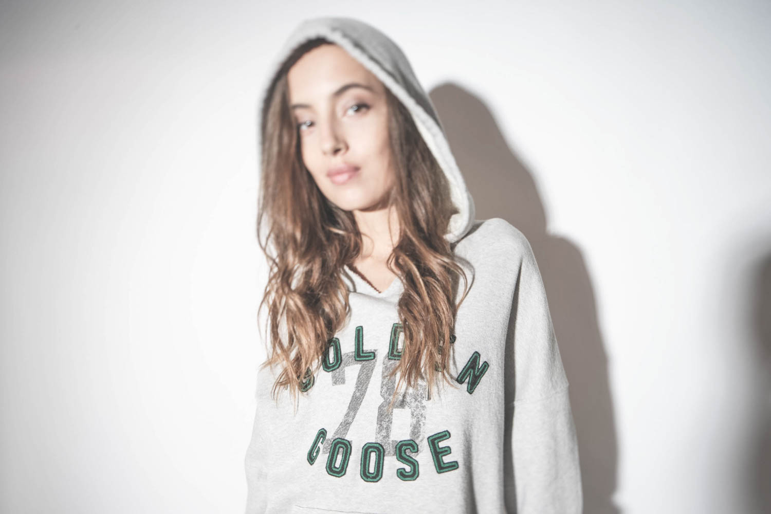 Sweatshirt à capuche gris chiné logo brodé Golden Goose 78. Détail du logo cousu et brodé vert et noir.