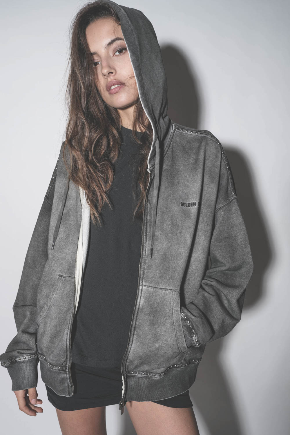 Veste sweatshirt à capuche grise délavée cloutée Golden Goose. Détail du logo brodé poitrine.