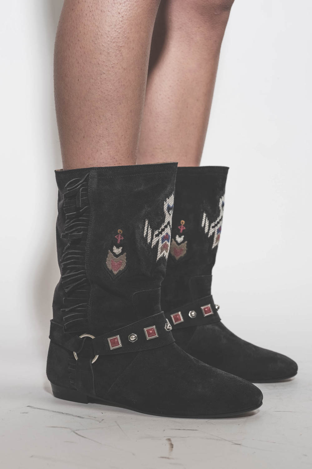 Boots plates en cuir suédé noir brodé et mini-franges sur les côtés Siani Isabel Marant. Portées de profil.