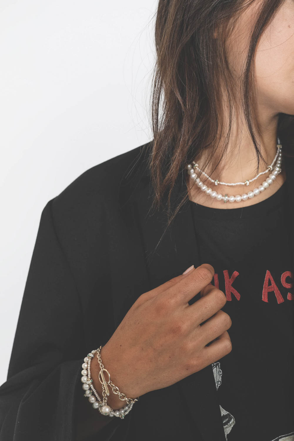 Bracelet chaine en or avec une perle d'eau douce, émeraudes et diamants Chelsea N°4 Pascale Monvoisin. Porté avec une veste noir.