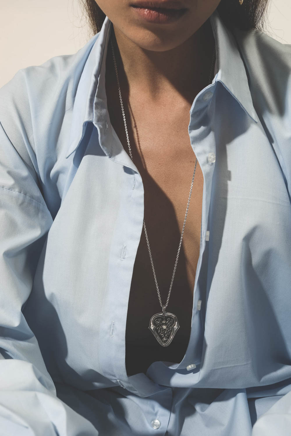 Pendentif médiator Tribute To Jimi en argent noirci et diamants De Jaegher. Porté avec une chemise en popeline bleue ciel.