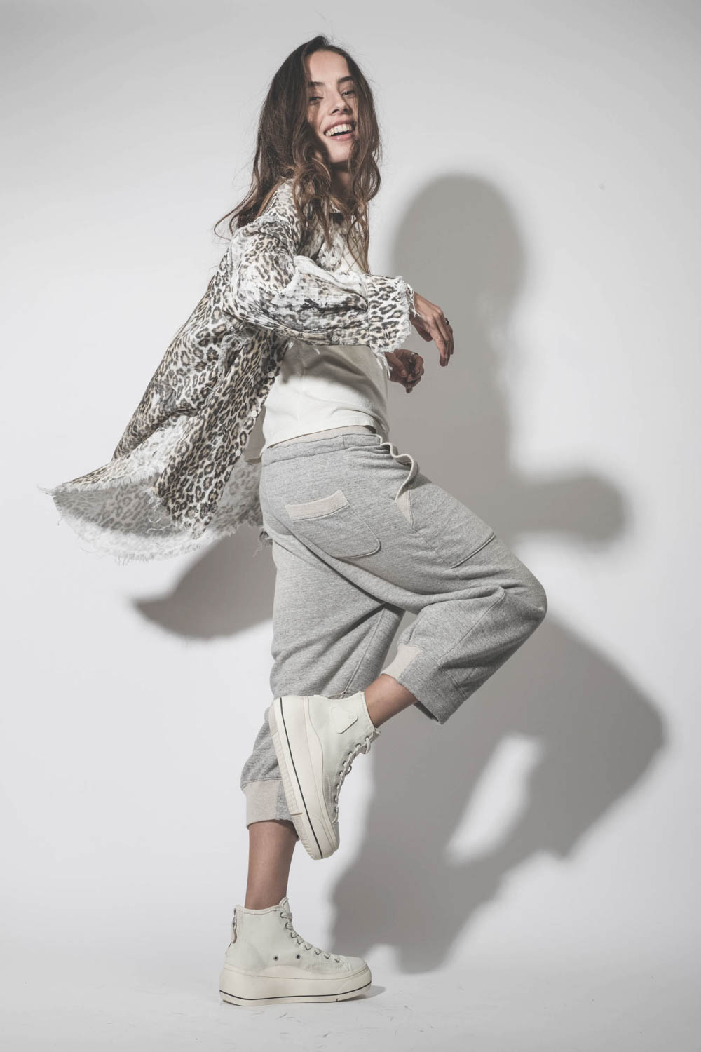 Chemise oversize en coton imprimé léopard délavé bord franc Shredded léopard R13. Porté avec un pantalon de jogging gris.