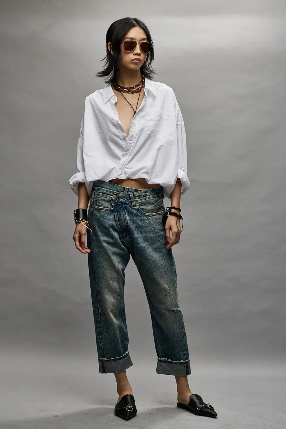 Jean Crossover bleu délavage Kelly R13 Denim. Porté avec une chemise blanche.