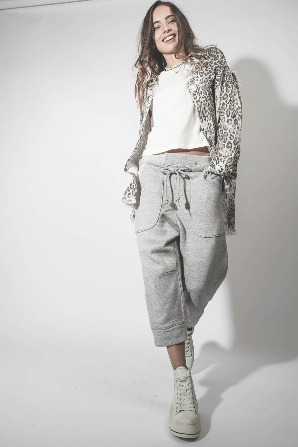 Pantalon de jogging court et oversize en molleton gris chiné Deconstructed Cropped Sweatpant Heather Grey R13. Porté avec des sneakers compensées en toile blanche.