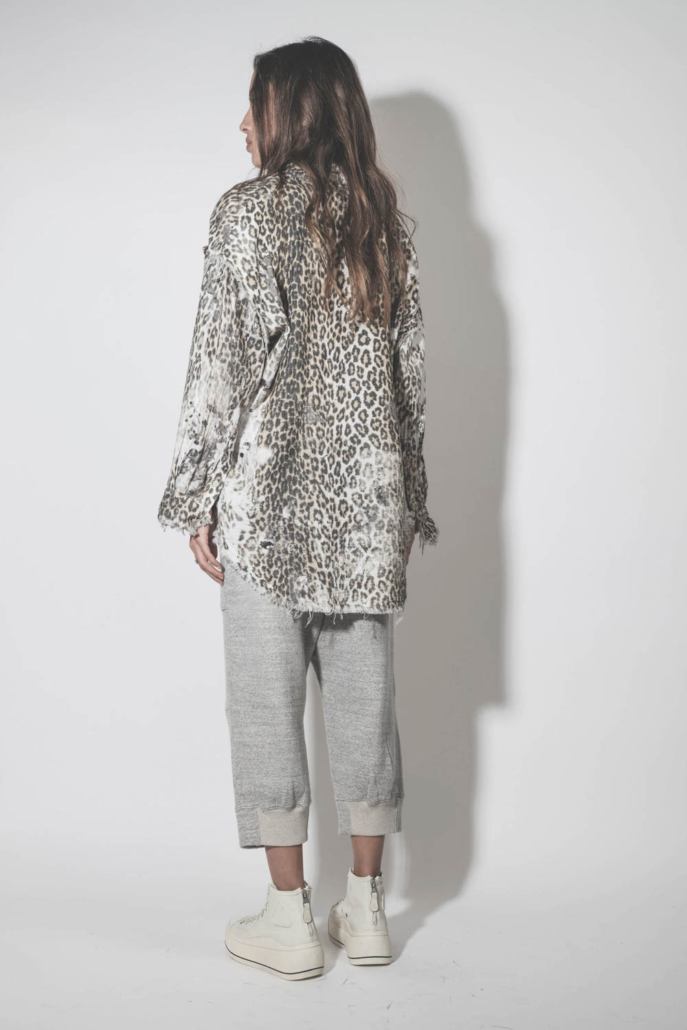 Pantalon de jogging court et oversize en molleton gris chiné Deconstructed Cropped Sweatpant Heather Grey R13. Porté de dos avec une chemise léopard.