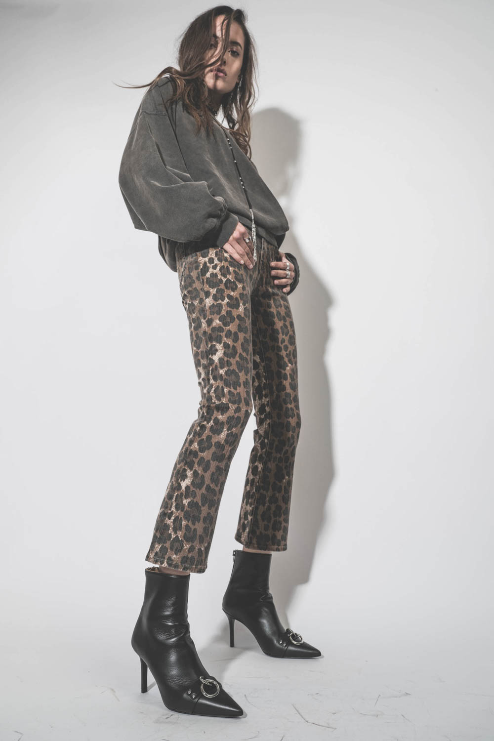 Jean Skinny taille basse court et légèrement évasé en jean léopard délavé Kick Fit R13. Porté avec des boots à talons en cuir noir. 